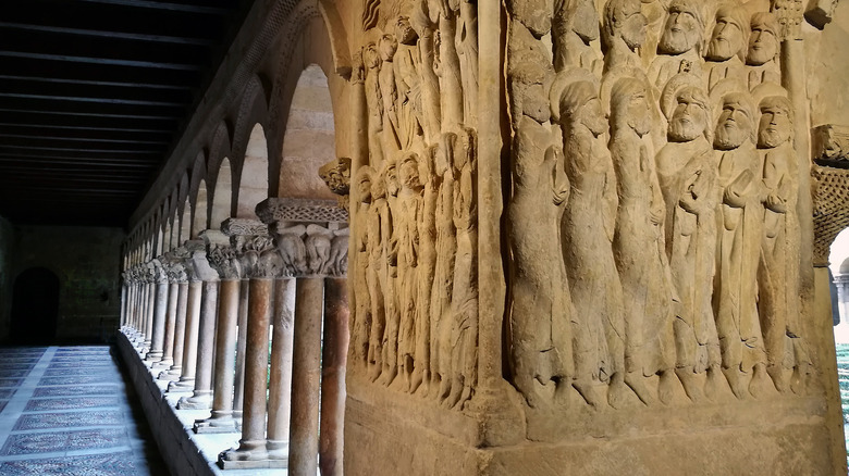 Sculpture of people praying in colonaded portico