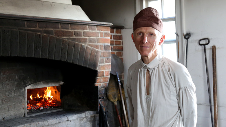 colonial reenactor next to oven