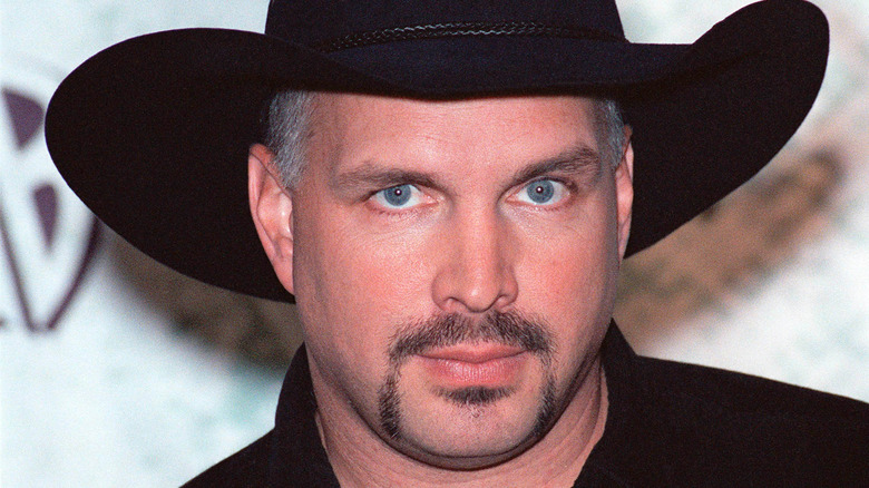 Garth Brooks with goatee in black hat and shirt