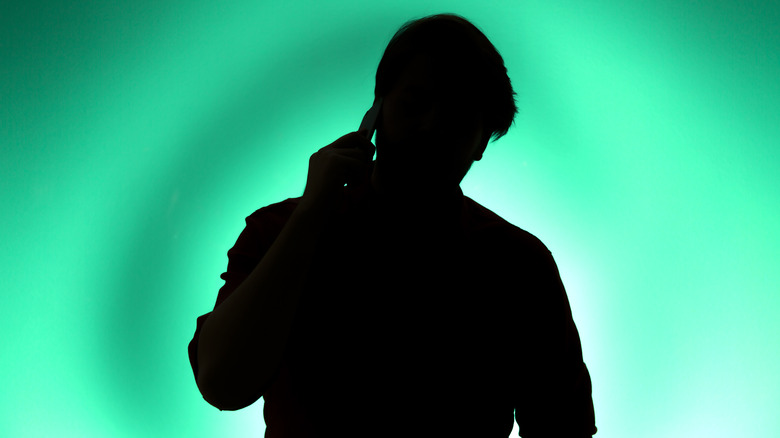 silhouette of a man holding a phone