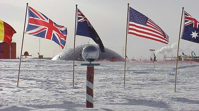 Ceremonial marker at the South Pole with flags