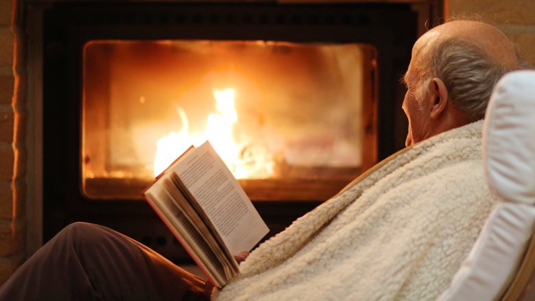 old man sitting by fire