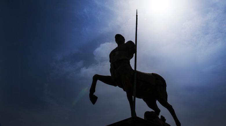 statue of a centaur under dark sky
