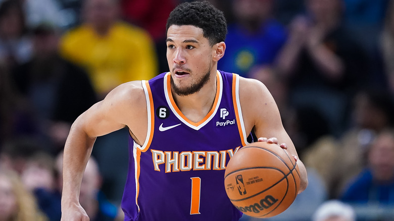 Devin Booker dribbling basketball Phoenix shirt