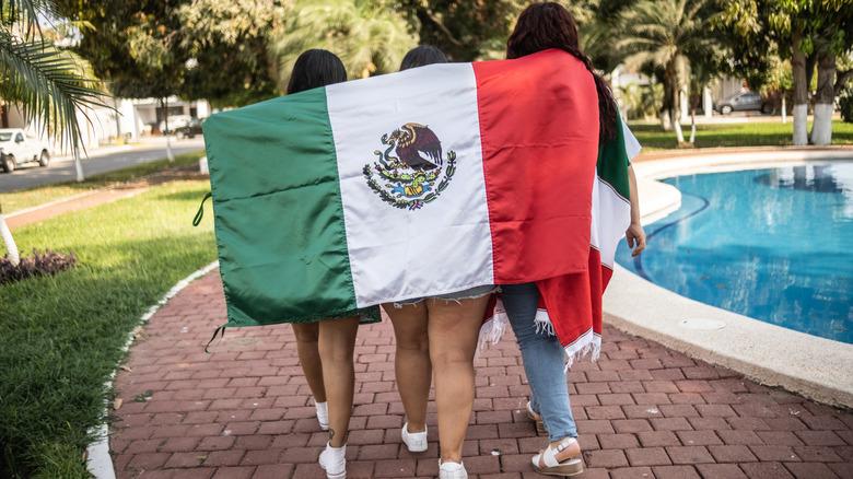 three women holding Mexican flag 