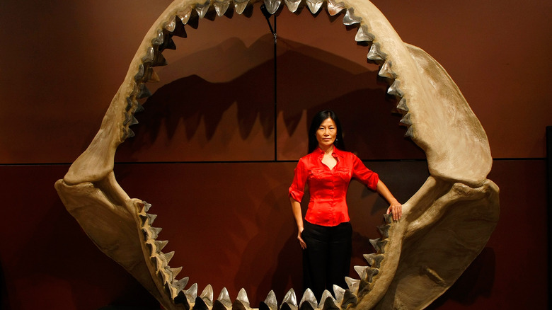 woman standing inside of model of megalodon mouth 