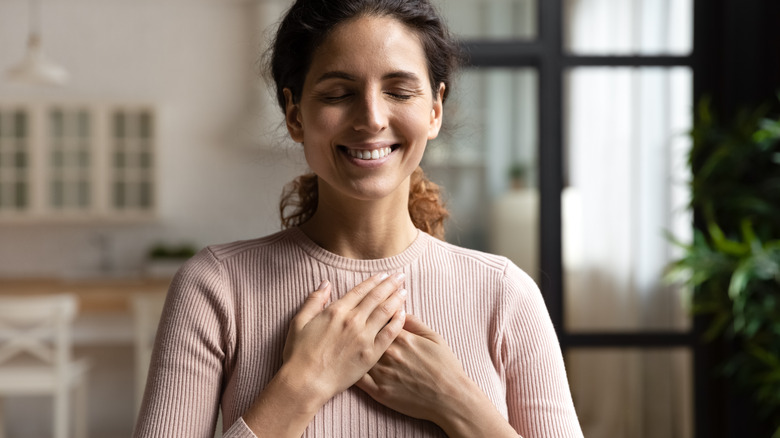 woman with hands over heart