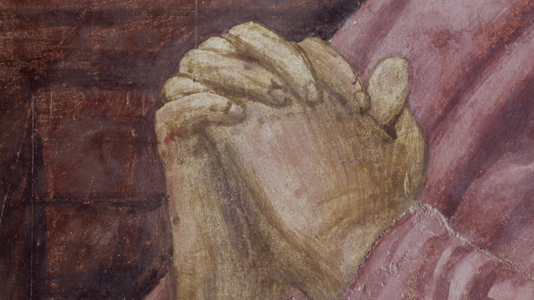 Fresco detail of hands joined in prayer