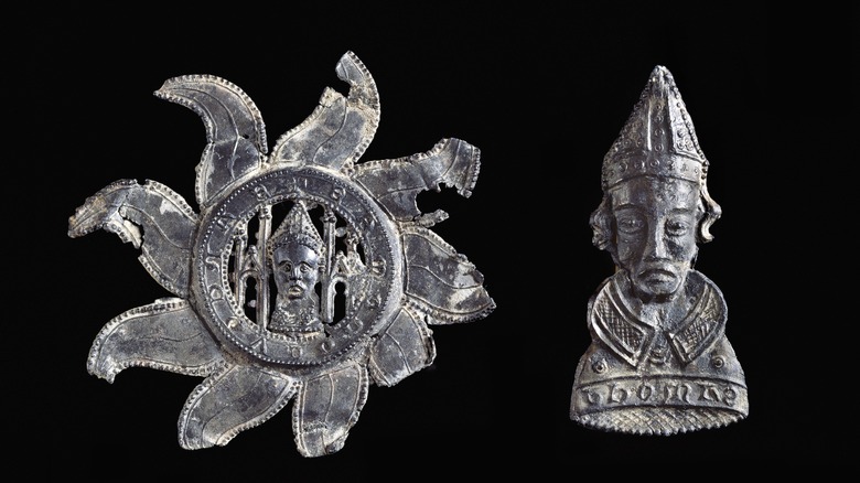 Two medieval pilgrim badges from Canterbury Cathedral, black background