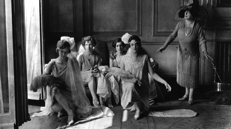 Debutantes taking lessons in court etiquette and deportment at a Kensington Academy. Miss Belle harding instructing in the art of curtseying