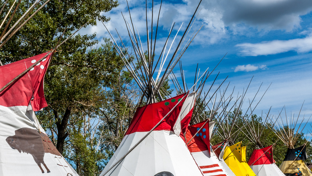 Traditional Blackfoot teepees under blue sky