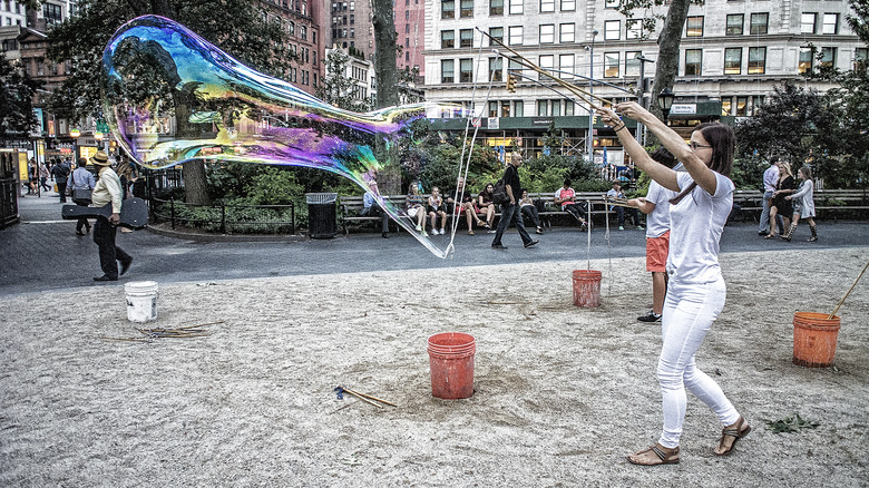 Person blowing large bubble park