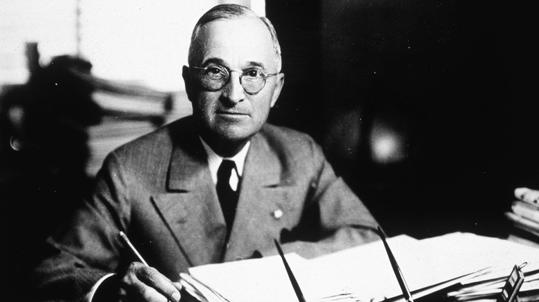 Harry Truman at desk with pen