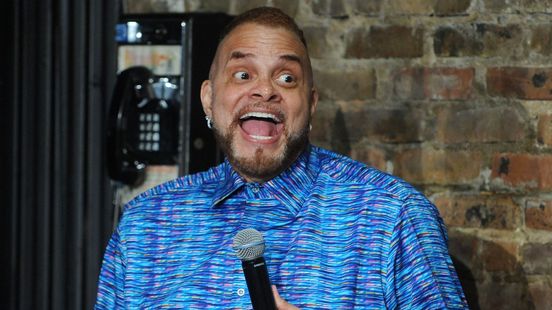 Sinbad doing comedy routine while smiling