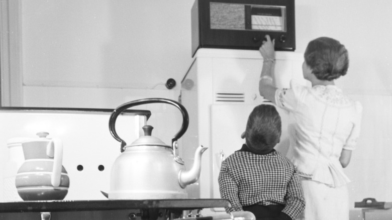 Mother and son listening to radio in kitchen