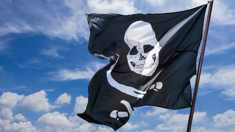 A skull and bones pirate flag flaps in the wind