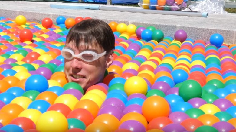 man swimming in ball pit