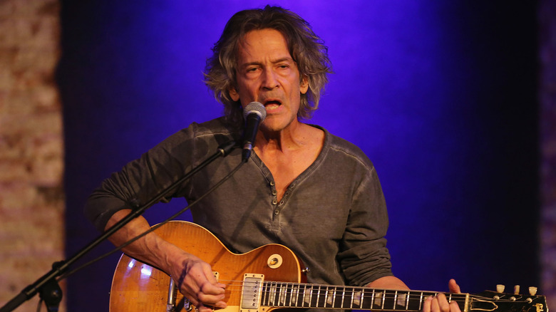 Billy Squier playing guitar and singing onstage