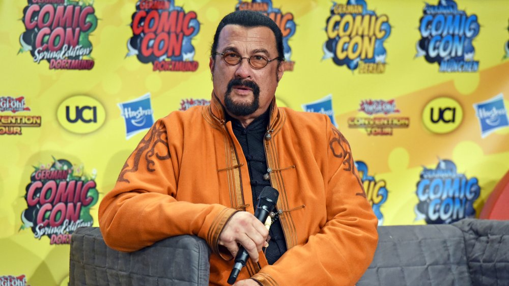 A candid photo of Steven Seagal dressed in an orange jacket