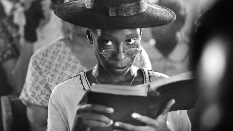 Whoopi Goldberg looks up from book