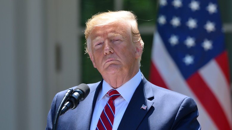 Donald Trump standing in front of an American Flag