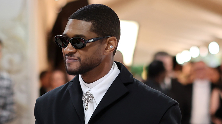 Usher walks with sunglasses