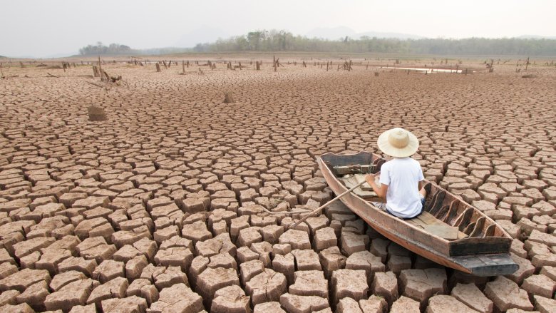 man in boat on dried up lake