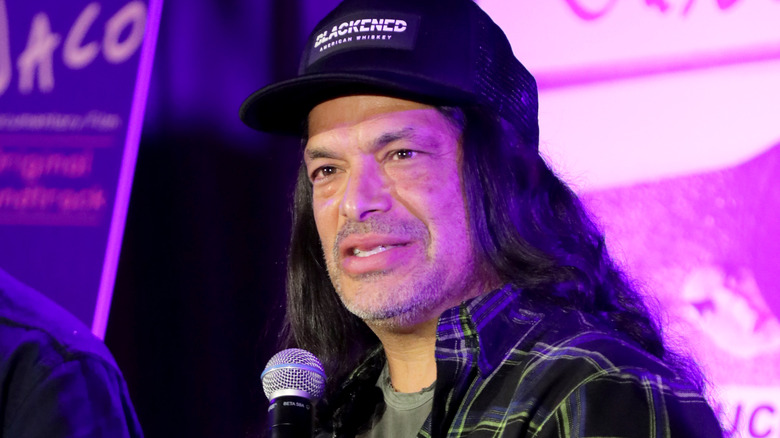 Robert Trujillo in cap with microphone