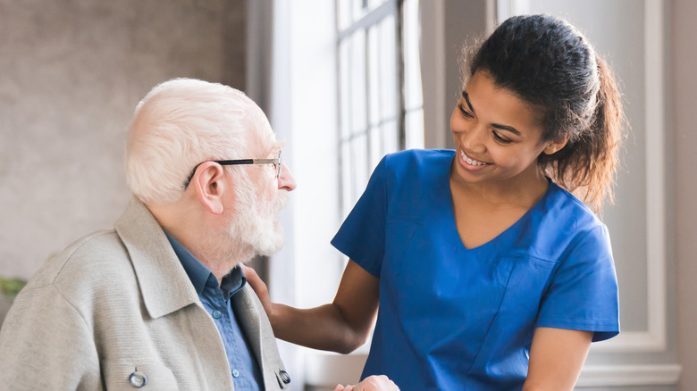 nurse aiding elderly patient