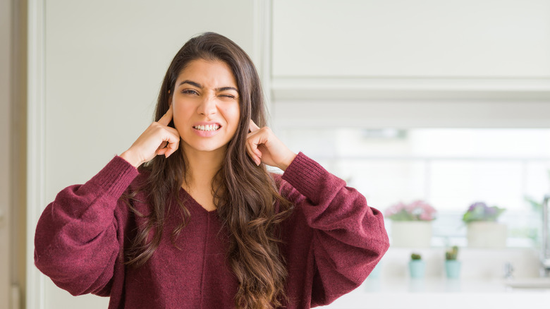 woman covering ears