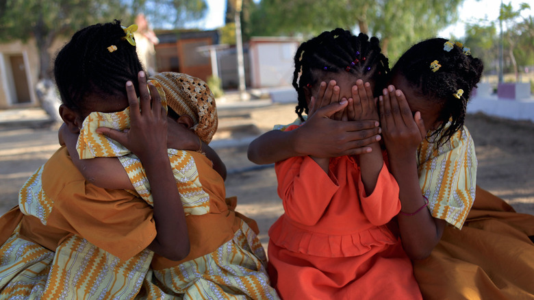 Children covering their and others' faces