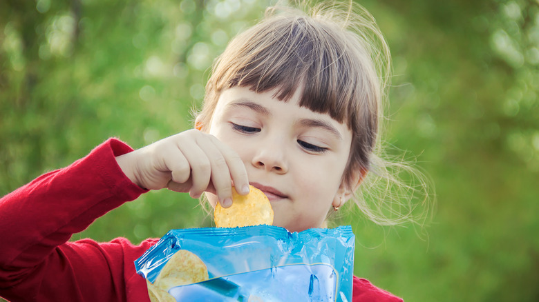 Child eats potato chips