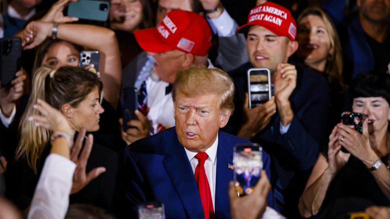 Trump frowning surrounded by fans