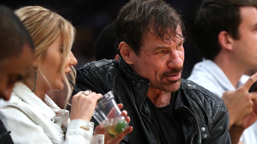 Henry Nicholas and guest at basketball game