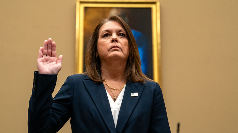 Kimberly Cheatle with arm raised taking oath