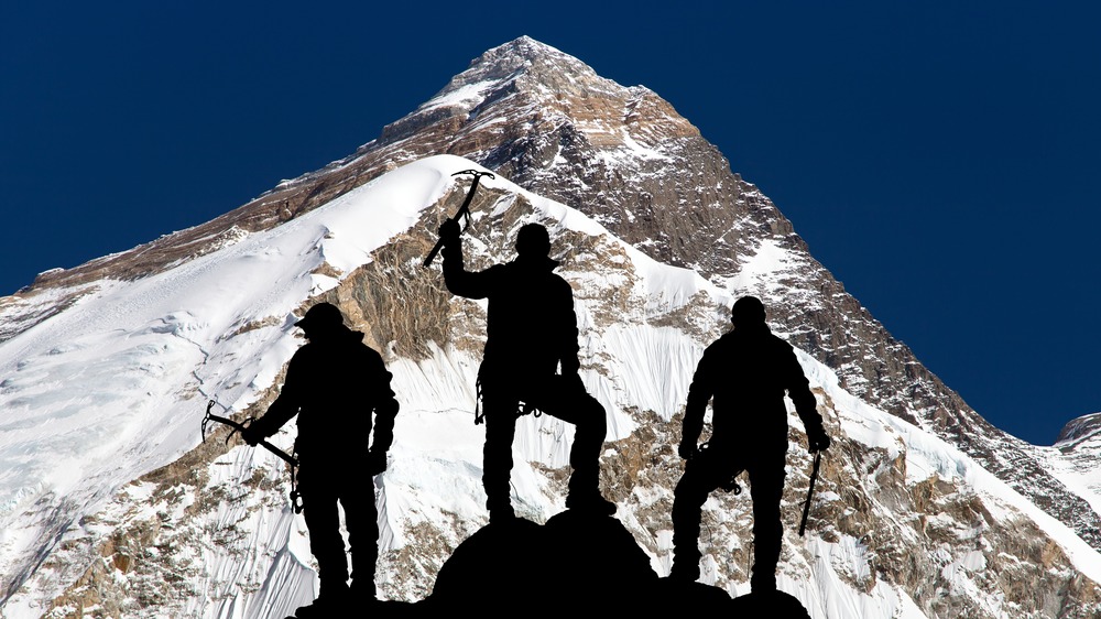 Three climbers in silhouette on Mt. Everest