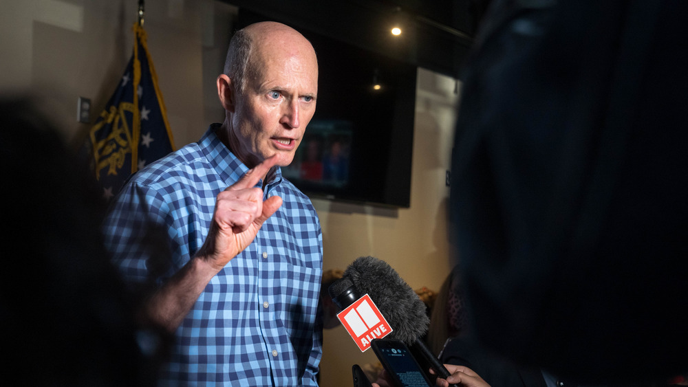 Rick Scott wearing plaid shirt