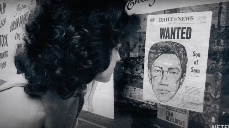 Young woman looking at a Son of Sam wanted poster