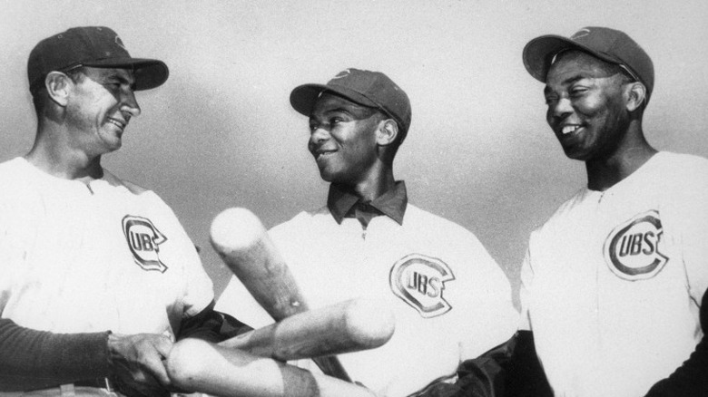Ernie Banks and teammates, holding bats and smiling