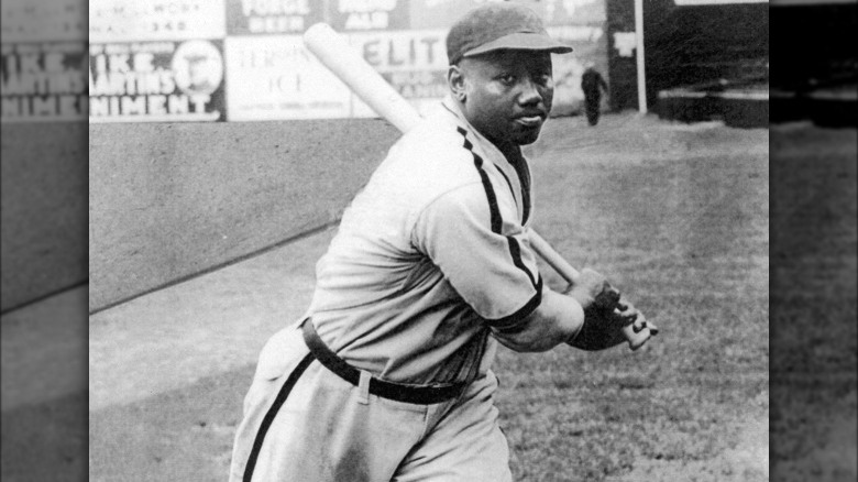 Josh Gibson white uniform and cap swinging bat in stadium