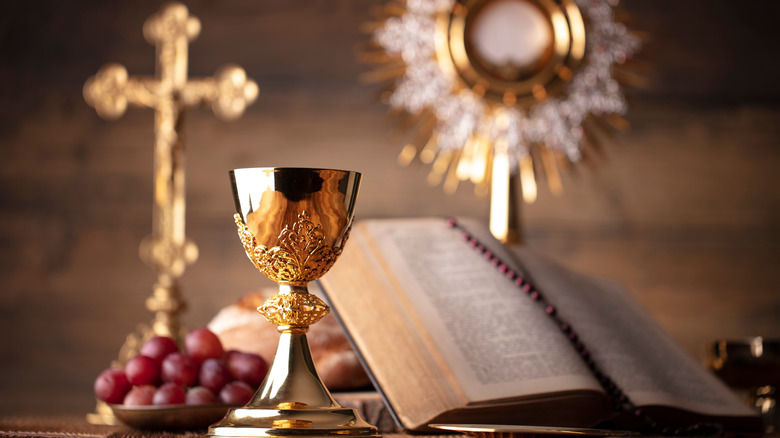 Cross, cup, and bible with grapes