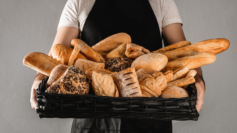 baker holding tray of bread