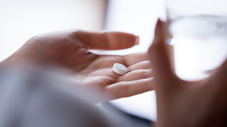 woman holding pill