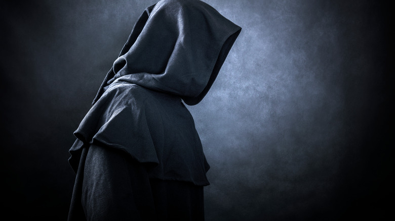 hooded figure in the dark