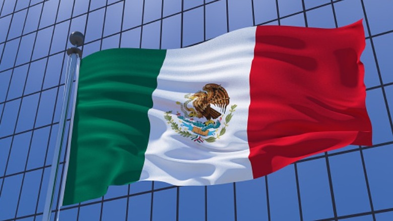 Mexican flag against skyscraper