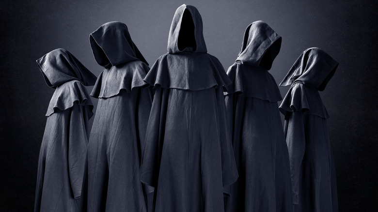 five hooded figures in a cult