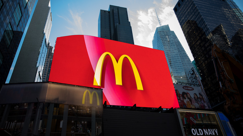 A billboard displays McDonald's Corp. signage outside a restaurant in the Times Square neighborhood, skyscrapers appear in the background with an old navy advertisement and store to its right side