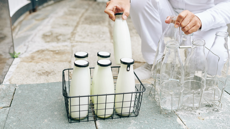 milkman putting bottles in wire basket