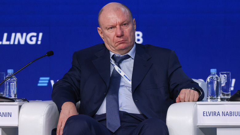 Amiable Vladimir Potanin sitting in chair