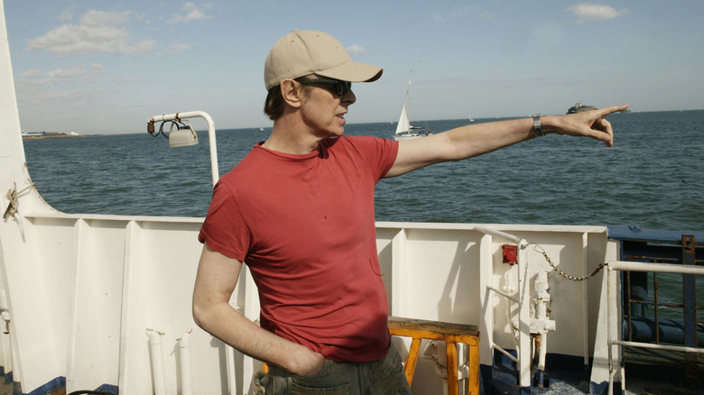 David Bowie pointing out to sea in baseball cap